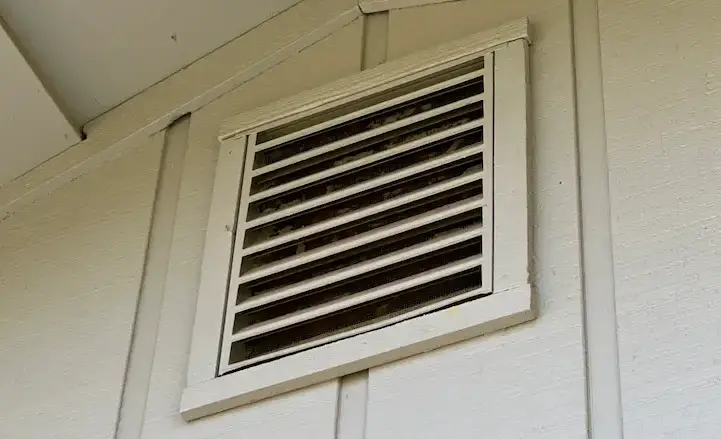 Gable vent with debris accumulation. In addition to being combustible, debris reduces airflow to the vented space and can lead to moisture issues over time.