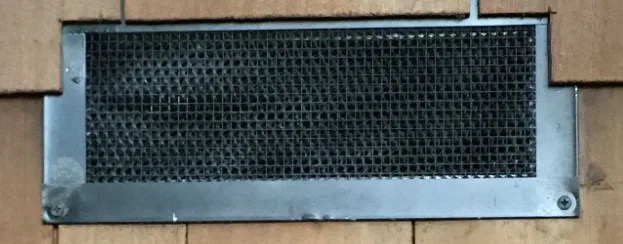 A newly installed rectangular Chapter 7A compliant Vulcan Vent with intumescent backing material that swells shut when exposed to flame