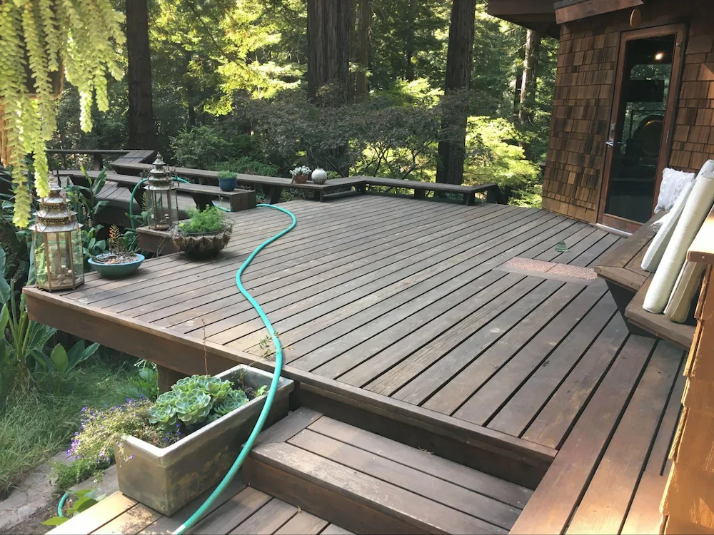 Softwood deck attached to structure with varying clearance to the ground due to hillside topology; this is a challenging scenario to mitigate due to deck’s size and its attached structure’s geometry.