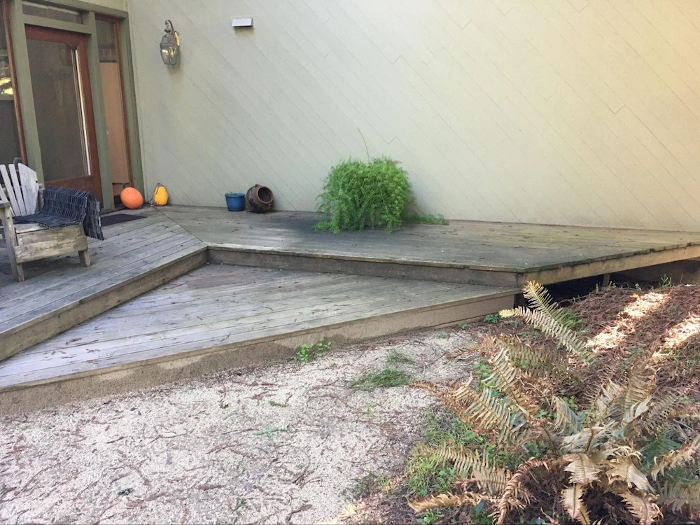 Softwood deck with less than 24 inches of ground clearance and partially enclosed with combustible fascia boards on the exterior perimeter.
