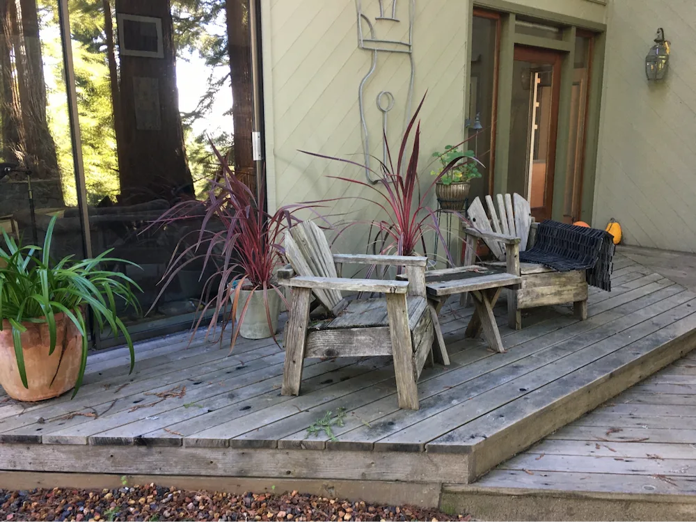 Softwood deck with combustible wood furniture stored. Plants in noncombustible ceramic pots are lower risk but could threaten the sliding glass door if they contained herbaceous or dead/dying plants or bark/wood mulch.