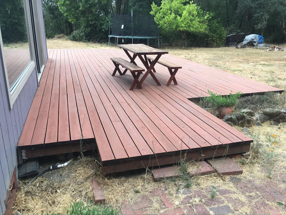Softwood deck with less than 24 inches of clearance to the ground. These can be challenging to mitigate due to restricted access under the deck, but screening with corrosion-resistant metal mesh mitigates debris accumulation and ember exposure