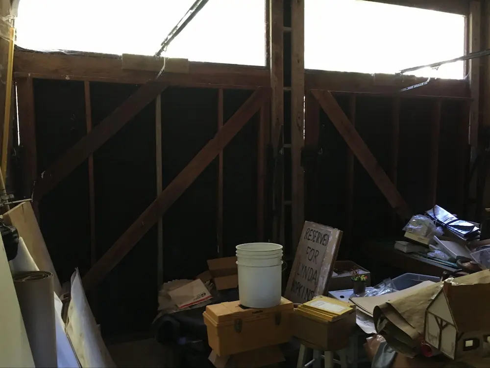 Interior of a two-car garage with wood doors with gaps larger than 1/8 inch in the upper left corner of both doors.