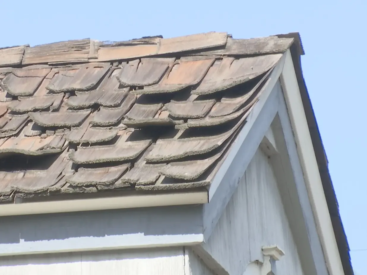 Wood shake roof covering in poor condition.