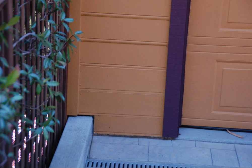 The lower two courses of wood (hardboard) siding have been replaced with a fiber cement product and painted to match. In this case, two courses of combustible siding were removed and replaced with a fiber-cement option that had a similar pattern.
